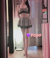 a woman in a black and white checkered outfit standing in front of a mirror